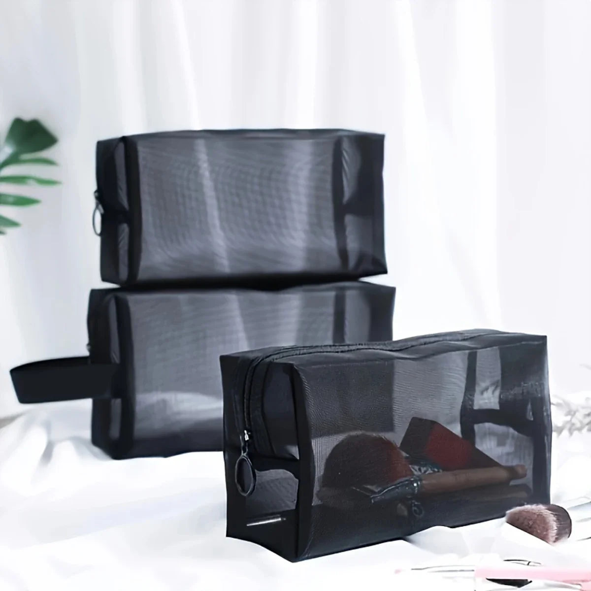 Black mesh cosmetic bag by Blushimmer featuring a zipper, portable makeup organizer for travel and toiletry storage.