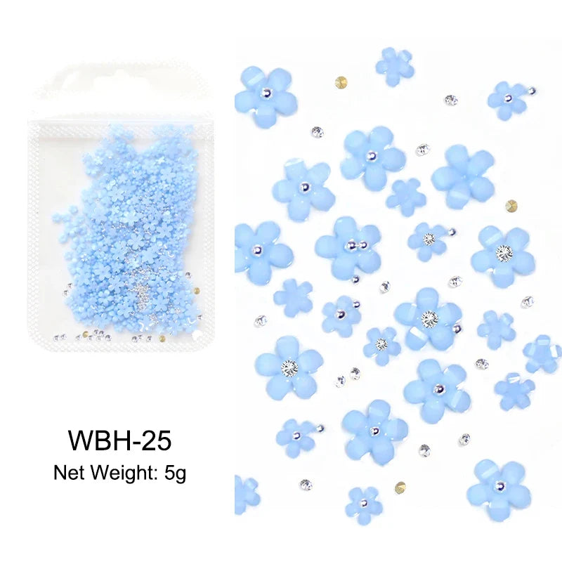 White acrylic flower nail art decorations with mixed size red and blue rhinestones for DIY manicure designs by Blushimmer.