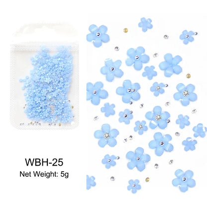 White acrylic flower nail art decorations with mixed size red and blue rhinestones for DIY manicure designs by Blushimmer.