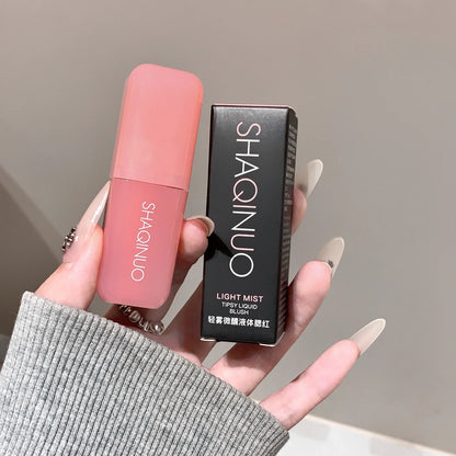 Blushimmer Light Blush Liquid Rouge in natural pink shade with moisturizing and brightening effects, displayed in a sleek bottle.