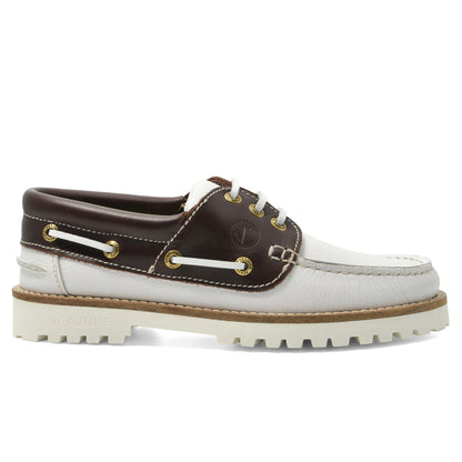 Seajure Women’s Izola boat shoes in navy with white laces, featuring a low-profile design and casual slip-on style.