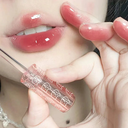Cherry pink Blushimmer lip gloss with mirror finish and moisturizing glass lip oil, shining with a vibrant pink hue.