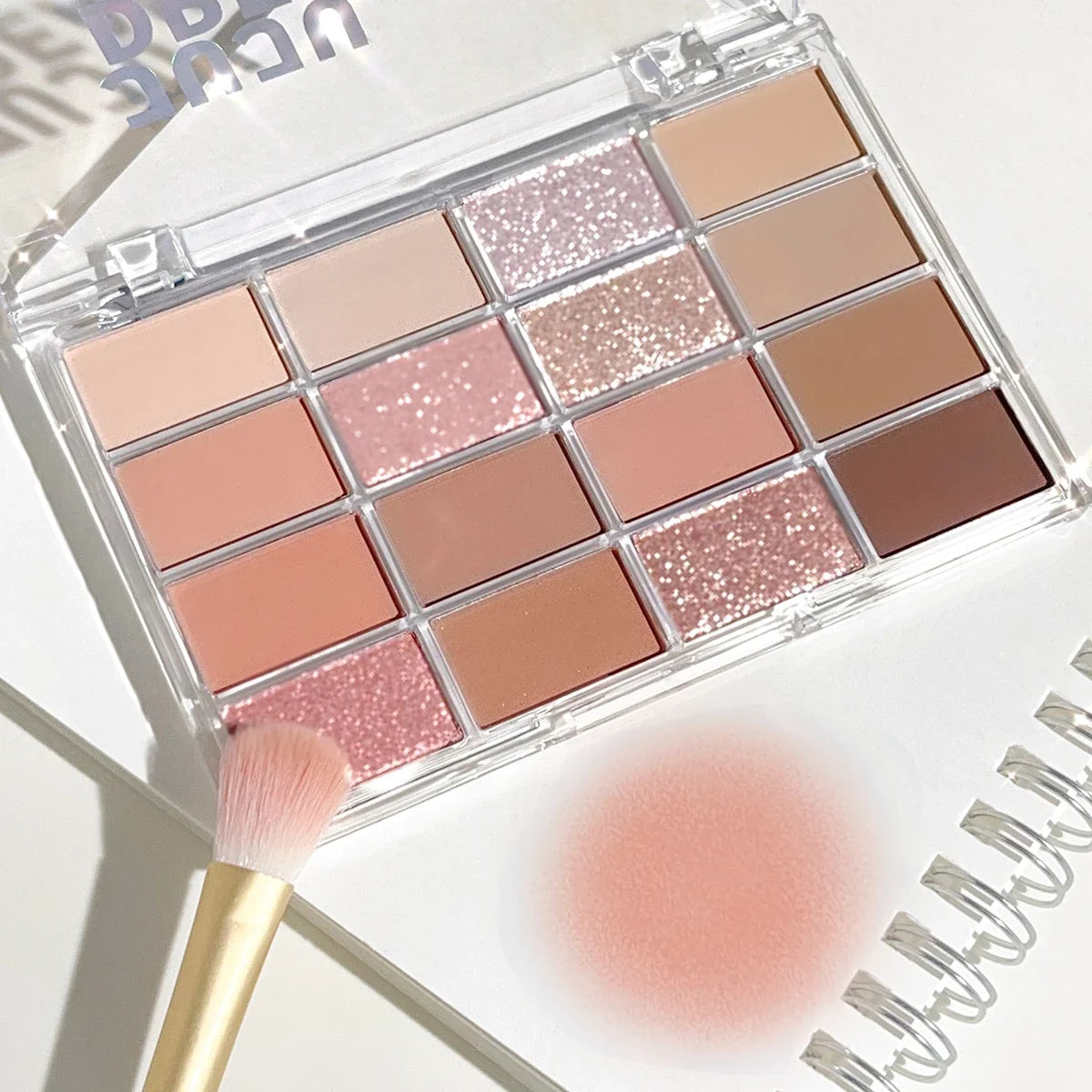 Blushimmer 16-color eyeshadow palette with pearlescent and matte shades in earthy tones for everyday makeup looks.