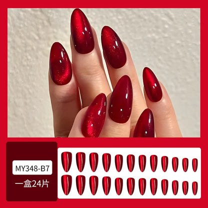 Set of 24 glossy red cat's eye press on nails by Blushimmer, almond-shaped, full cover false nails with nude color and detachable charms.