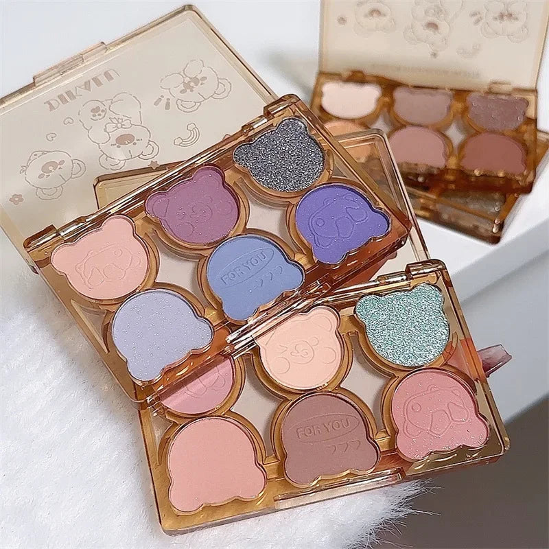Blushimmer 6-color matte and shimmering eyeshadow palette with smoky gray, red, black, and wine shades for eye makeup.