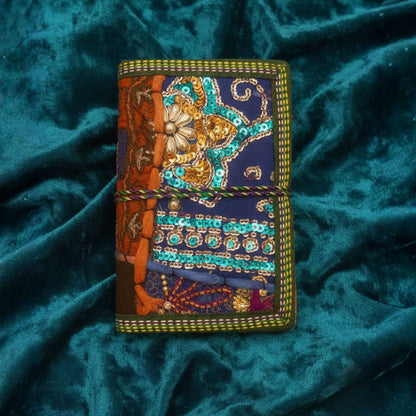 Handcrafted sari fabric bound notebook journal with vibrant, colorful sari textile cover, ideal for home decor or writing.