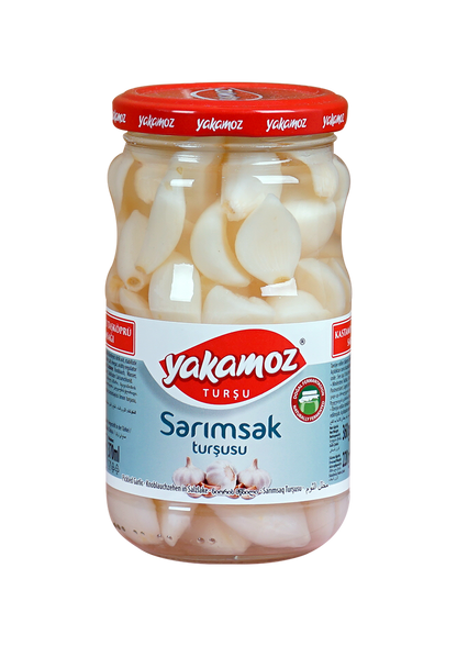 Glass jar of S101 Yakamoz pickled garlic, showing whole garlic cloves in brine, labeled as pickles in a clear glass jar.
