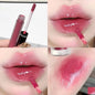 Blushimmer Berry Red translucent lip gloss with a hydrating, water-light texture and clear jelly finish on nude brown lips.