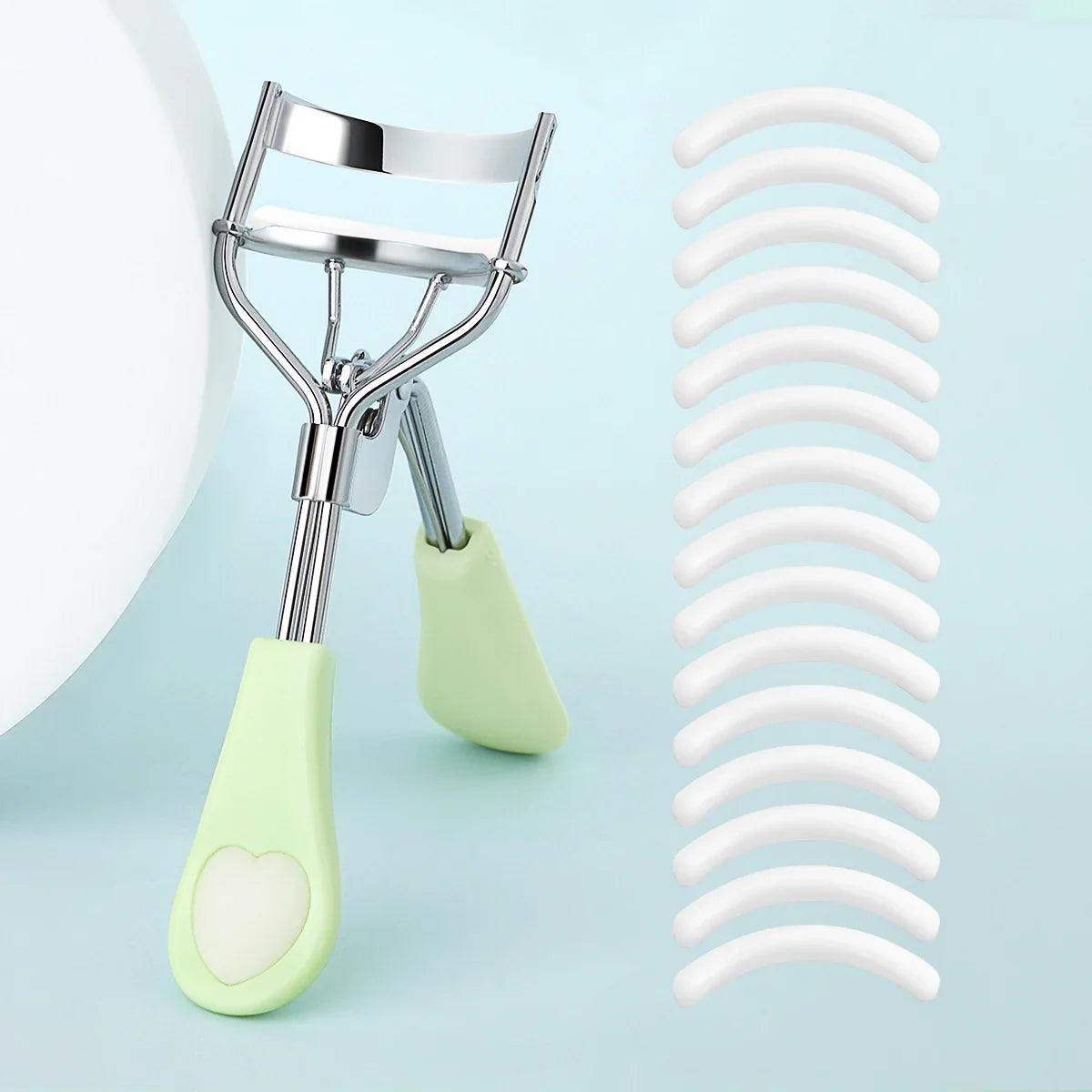 Blushimmer portable eyelash curler with stainless steel body and 15 silicone pads, designed for eyelash extension and curling.