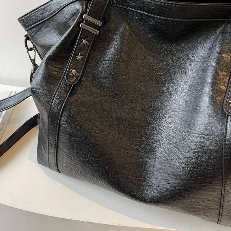 Black leather women's tote handbag by OBA, versatile shoulder and crossbody bag with spacious interior and sleek design.
