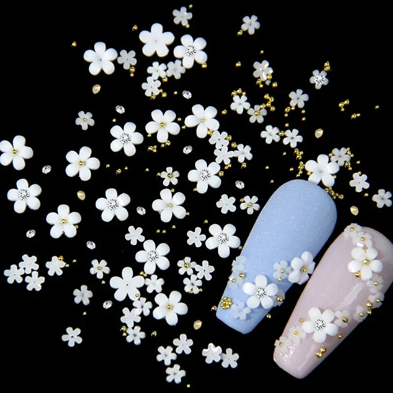 White acrylic flower nail art decorations with mixed size red and blue rhinestones for DIY manicure designs by Blushimmer.