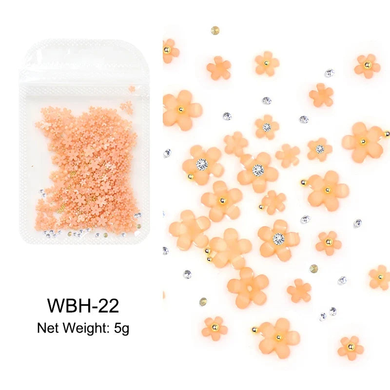 White acrylic flower nail art decorations with mixed size rhinestones and colorful gems for DIY manicure designs.