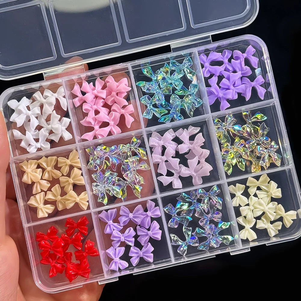 Assorted 3D gold bow, butterfly, and star nail metal charms on a white background for luxury nail art designs.