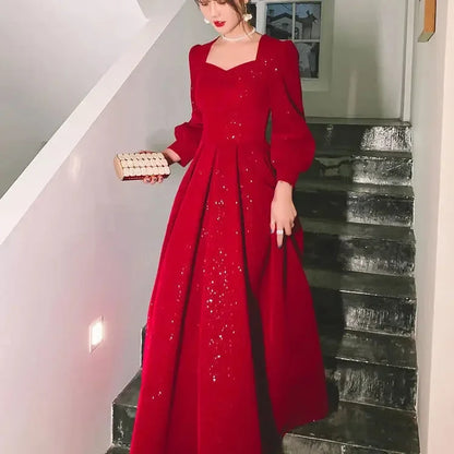 Elegant red luxury ceremony gown by Luxlife Brands featuring intricate detailing and flowing fabric for special occasions.