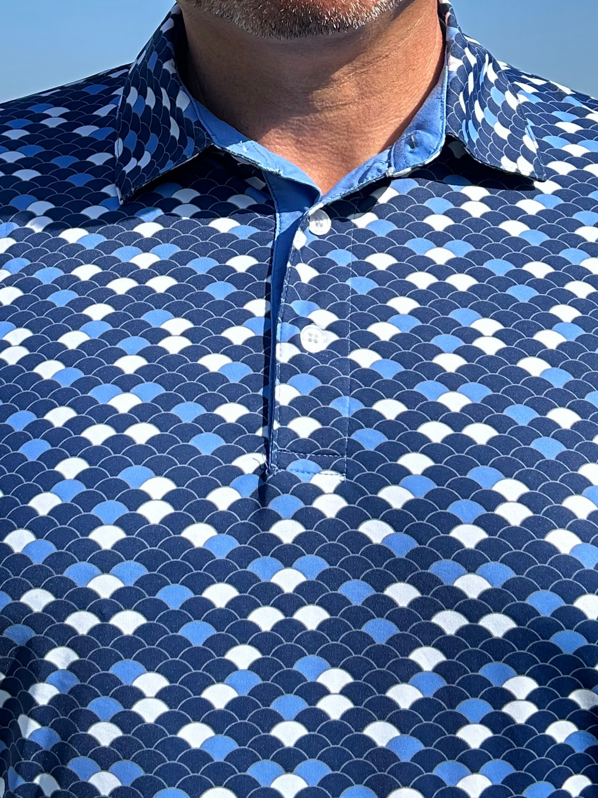 Close-up of a White Water Life Scales Polo shirt showing the fabric texture and detailed stitching.