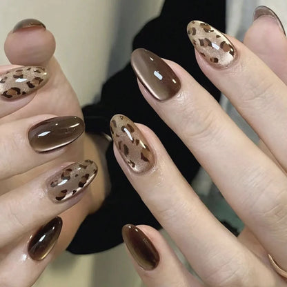 Set of 24 glossy red Cat's Eye press-on nails in nude color, almond shape, from Blushimmer with charms and detachable fake nails.
