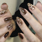 Set of 24 glossy red Cat's Eye press-on nails in nude color, almond shape, from Blushimmer with charms and detachable fake nails.