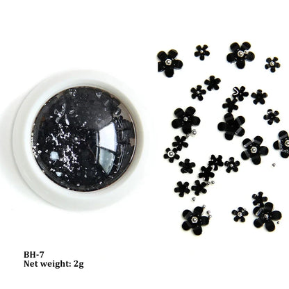 White acrylic flower nail art decorations with mixed size rhinestones and colorful gems for DIY manicure designs.