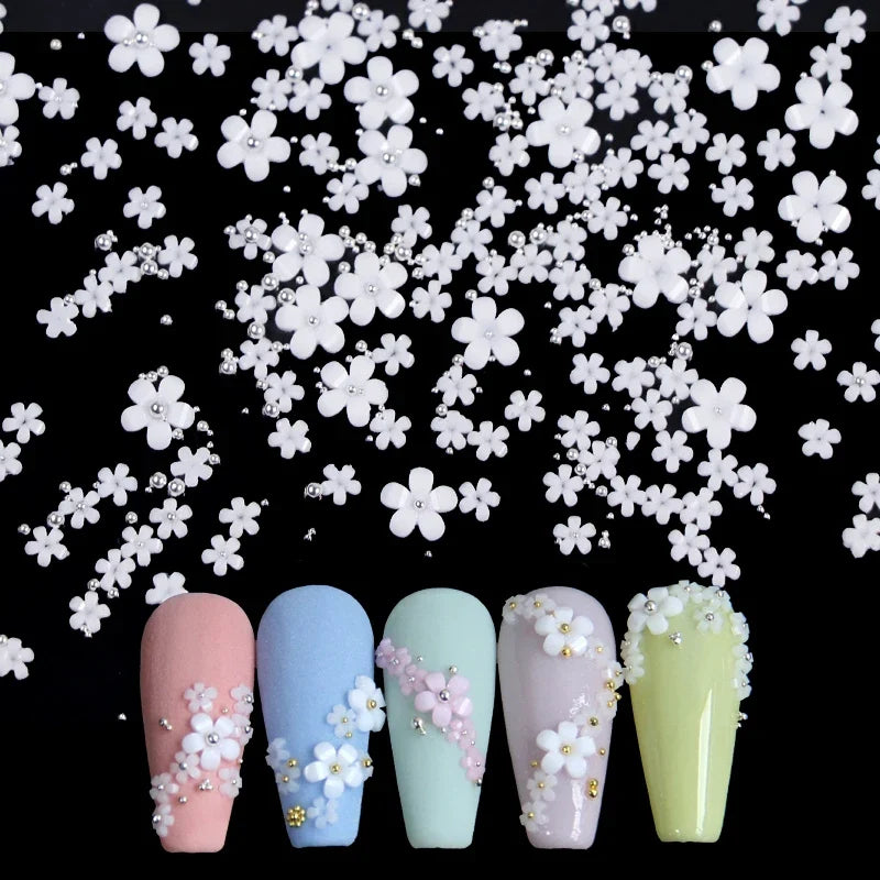 White acrylic flower nail art decorations with mixed size red and blue rhinestones for DIY manicure design by Blushimmer.