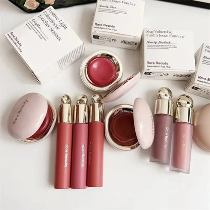 Blushimmer Rare Beauty melting cream blush with pearlescent matte finish, glitter highlighter, and nourishing lip gloss in a sleek container.