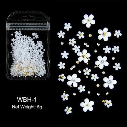 White acrylic flower nail art decorations with mixed size rhinestones and colorful gems for DIY manicure design.