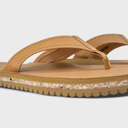 Pair of Fleks Seagrove Flip Flop sandals in sand color, showing side profile and angled view.