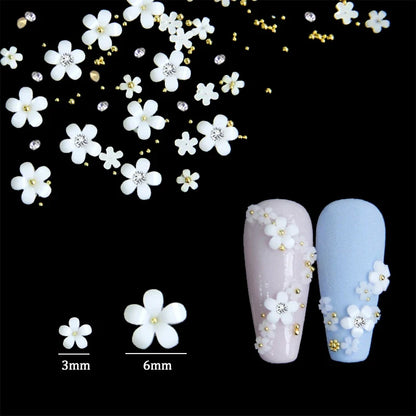 White acrylic flower nail art decorations with mixed size red and blue rhinestones for DIY manicure designs, by Blushimmer.