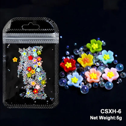 White acrylic flower nail art decorations with mixed red and blue rhinestones for DIY manicure design by Blushimmer.