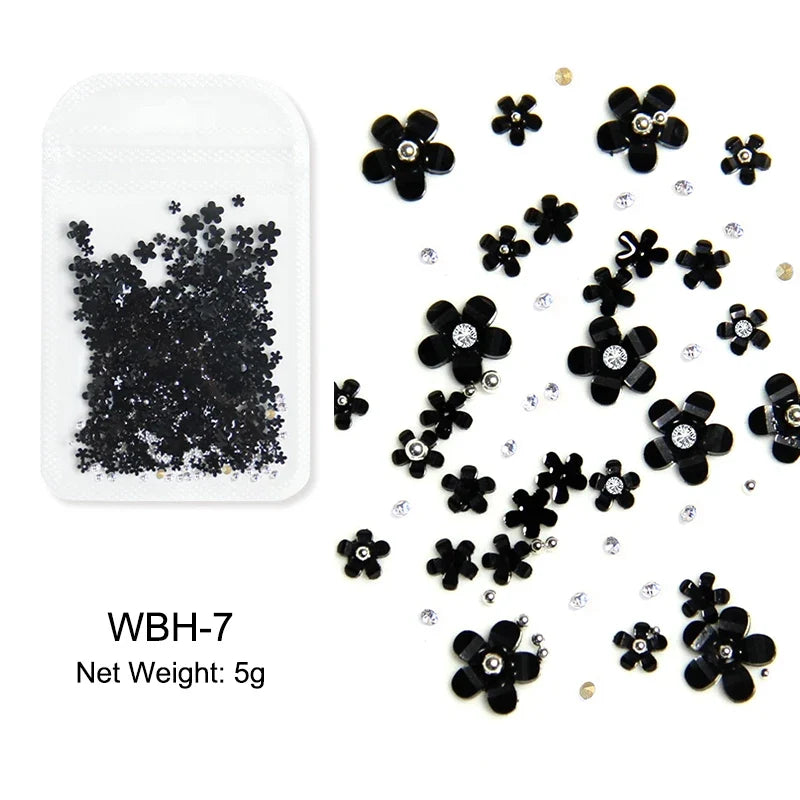 White acrylic flower nail art decorations with mixed size rhinestones and colorful gems for DIY manicure designs.