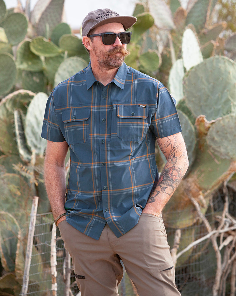 Dark gray and blue short sleeve Jack Knife SS shirt by Off The Grid Surplus, showcased in spring 2025 lifestyle image.