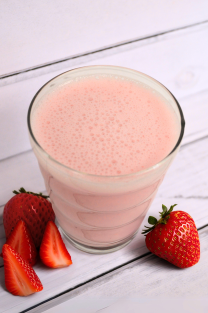 AmBari Nutrition Strawberry Blast smoothie shake in a clear glass with fresh strawberries and a creamy pink appearance.