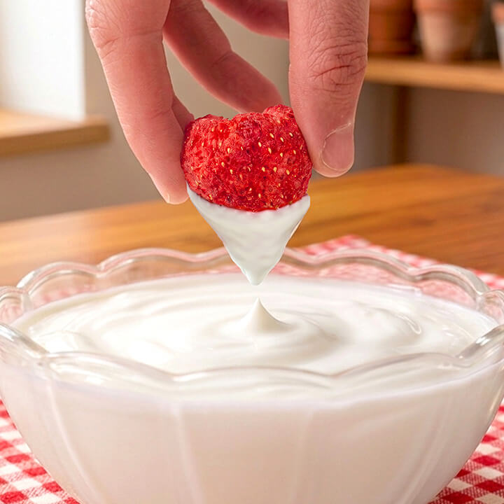 Sweetened freeze-dried whole strawberries from VFD.US, perfect for snacks or yogurt toppings, in a clear container.