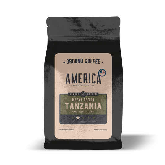 Ground Tanzania single origin coffee from America Supply Company LLC, showing fresh coffee grounds in a clear container.