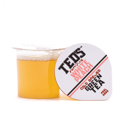 Glass of Ted's Famous White Peach Cold Brewed Green Tea by Java House, showcasing the tea's light color and fresh peach flavor.