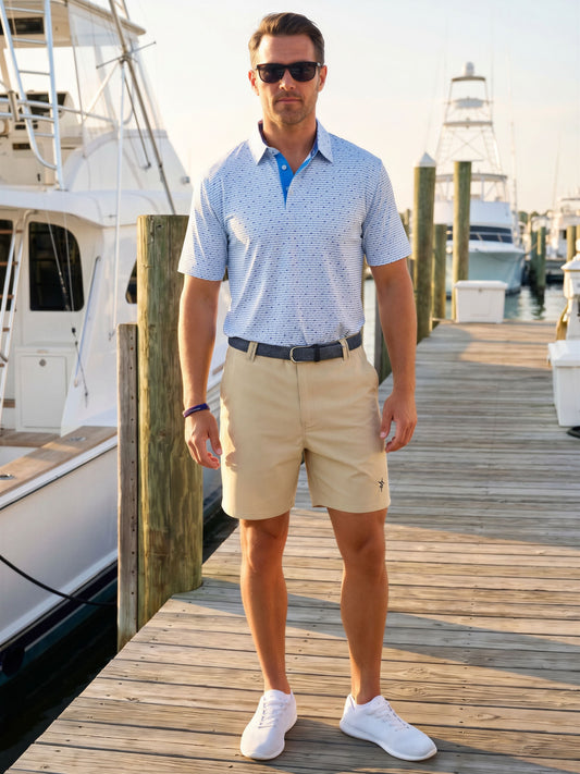 Light blue and navy Tuna Performance Polo by White Water Life displayed on a boat dock, showcasing casual, sporty style.