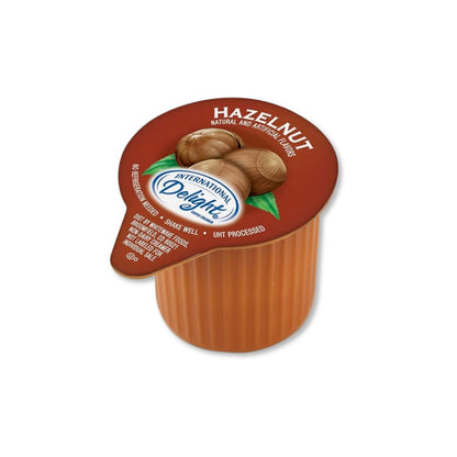 Single-serve cups of International Delight Hazelnut Coffee Creamer by Candy In Bulk, with creamy hazelnut flavor and convenient packaging.