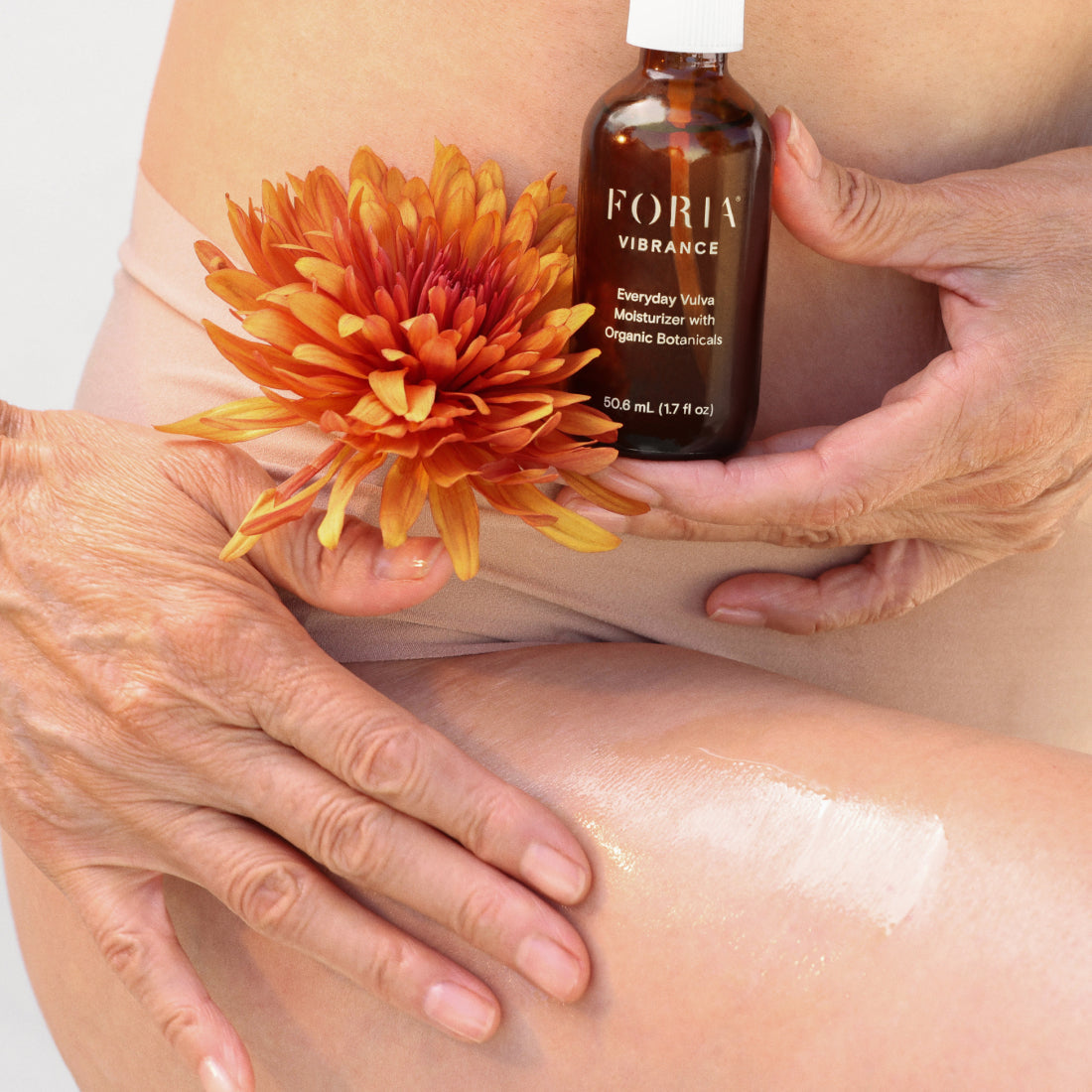 Foria Everyday Vulva Moisturizer with organic botanicals, showing smooth, creamy texture in a natural setting.