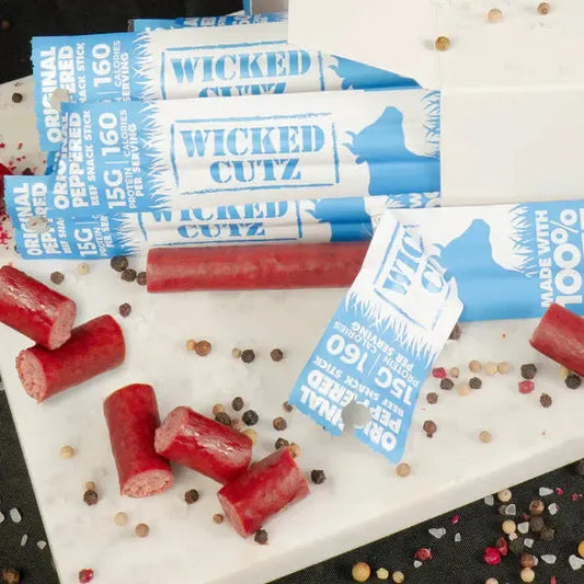 Original Wicked Cutz beef sticks by AmBari Nutrition, showing crispy, seasoned beef snack sticks in a natural setting.