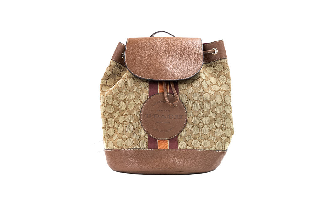 Coach Dempsey Khaki Saddle Signature Jacquard Canvas Patch Backpack with adjustable straps and multiple compartments.