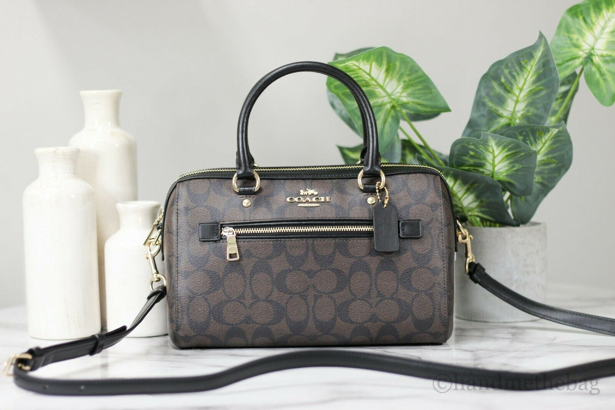 Coach Rowan brown and black signature leather medium satchel handbag with top handles and gold-tone hardware.