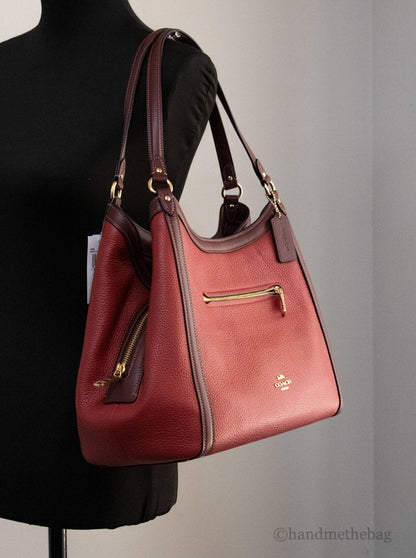 Coach Kristy Red Apple leather shoulder bag with triple compartments, featuring a stylish design and sturdy strap.