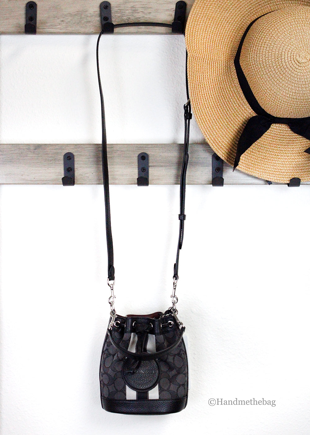 Coach Dempsey Mini Black Jacquard Canvas Patch Crossbody Bucket bag with adjustable strap and patchwork design.