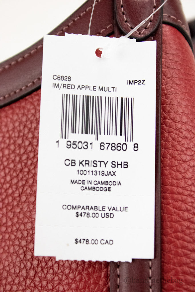 Coach Kristy red apple leather shoulder bag with triple compartments, featuring a stylish design and adjustable strap.