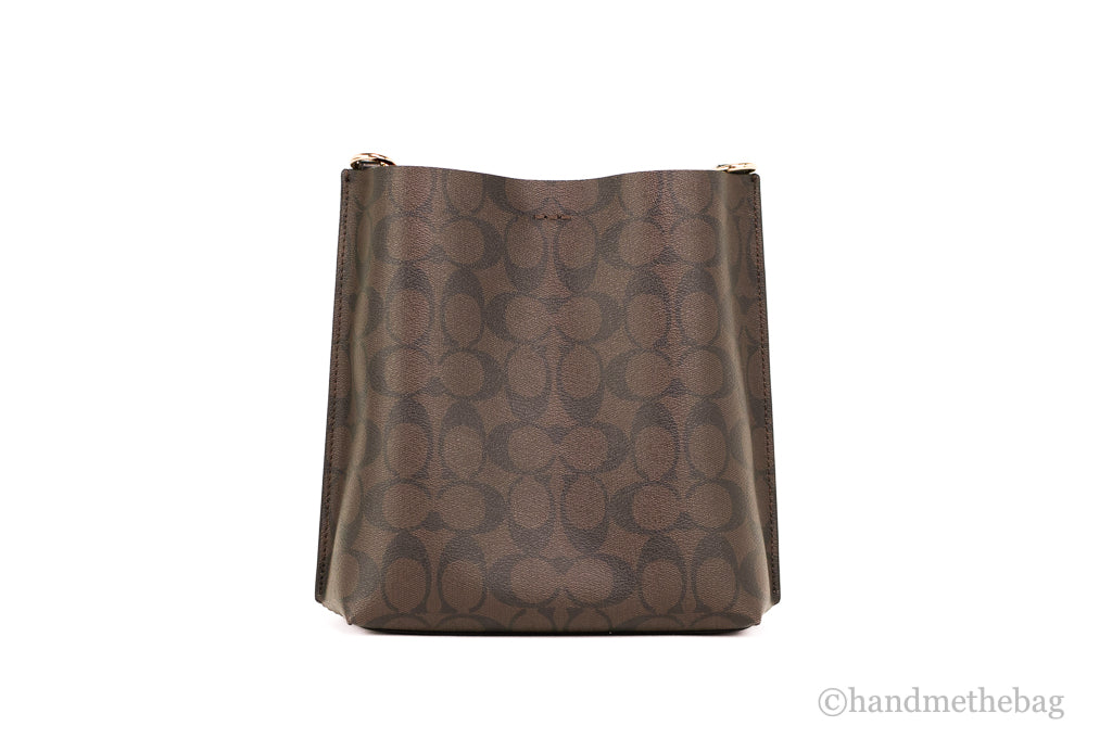 Coach Mollie 22 small brown and black coated canvas bucket crossbody handbag with adjustable strap and top handle.