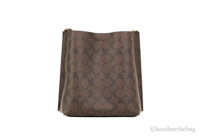 Coach Mollie 22 small brown and black coated canvas bucket crossbody handbag with adjustable strap and top handle.