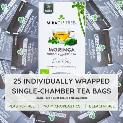 Organic Moringa Tea Earl Grey herbal tea by Miracle Tree, featuring loose tea leaves and a tea infuser on a wooden surface.