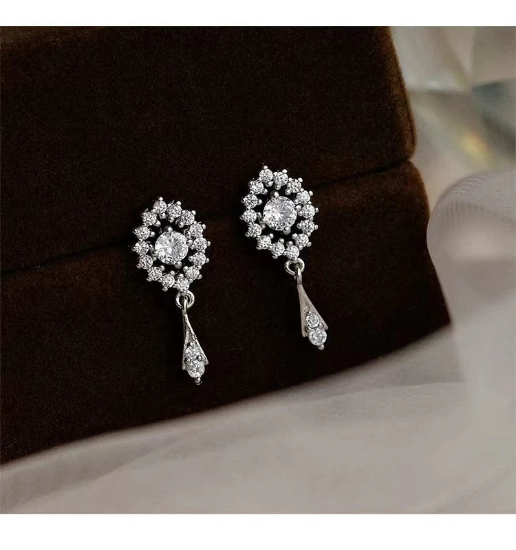 Silver color zircon inlaid clover tassel earrings for women with delicate chain pendants, stylish party jewelry and accessories.