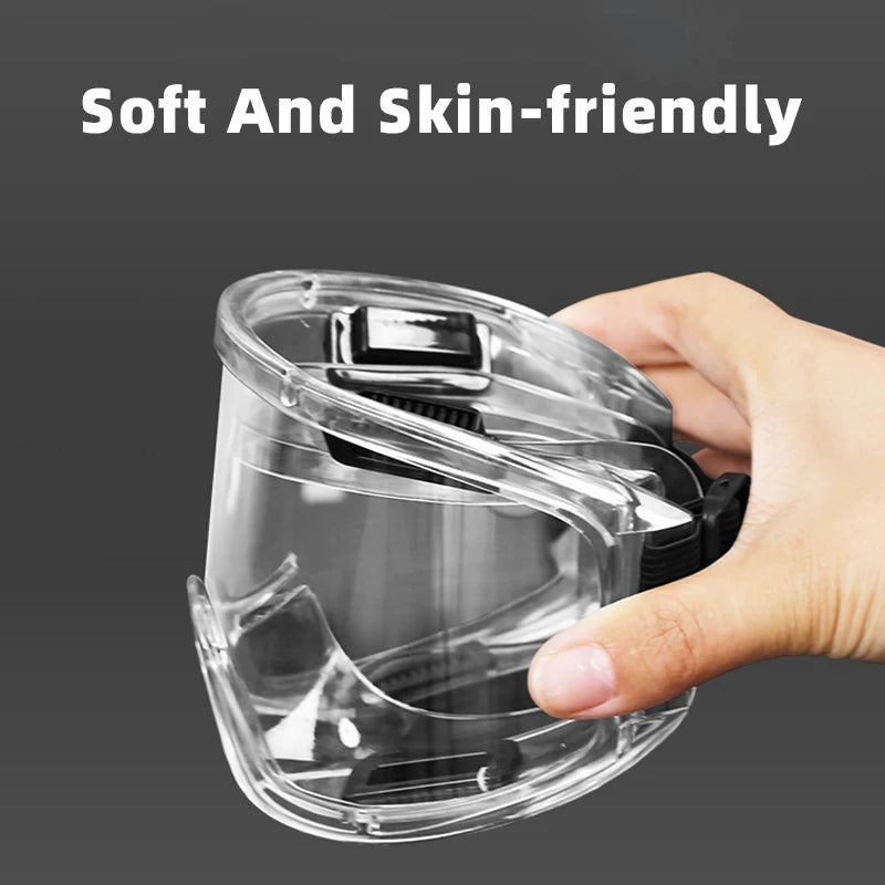 Clear anti-fog safety glasses with adjustable straps, designed for riding, skiing, and sports, protecting against dust, splashes, and sand.