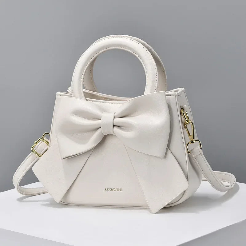 Fashion casual women's handbags with cute bows in black, white, blue, and khaki; trendy PU shoulder and underarm bags.