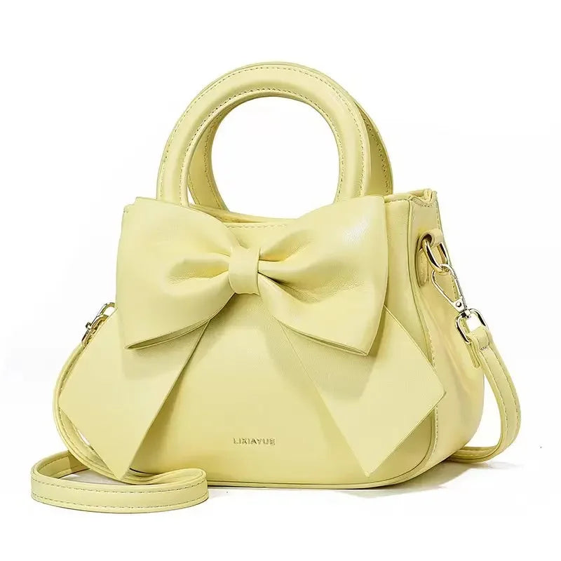 Casual women's handbags with bows in black, white, blue, and khaki PU leather, featuring trendy shoulder and underarm styles.